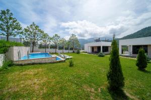 迪利然Cinema Pool & Hot Tub Luxe White Villa Dilijan的院子里有游泳池的房子