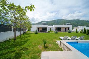迪利然Cinema Pool & Hot Tub Luxe White Villa Dilijan的带院子和游泳池的房子