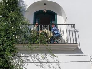 two men sitting on a balcony of a building at Dimora Violetta in Alberobello