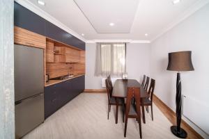 迪利然Cinema Pool & Hot Tub Luxe White Villa Dilijan的厨房里有一张桌子和几把椅子