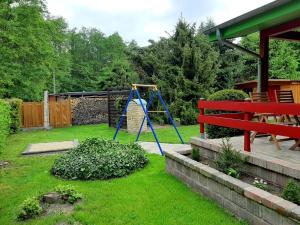 einen Hof mit Spielplatz mit Schaukel in der Unterkunft Ferienhaus Sonneneck mit Motorboot und Kanu in Basedow