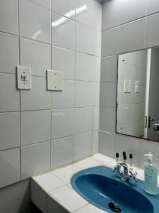 a bathroom with a blue sink and a mirror at Skyfly Bed & Breakfast in Manzini +126 photos