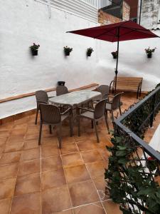 a patio with a table and chairs and an umbrella at Casa en el centro del pueblo in El Morell