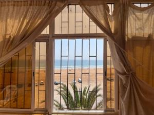 a room with a large window looking out at the beach at DAR Nezha in Agadir