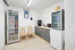 a kitchen with a refrigerator and a table and chairs at Haus unter Gerlitzen in Bodensdorf