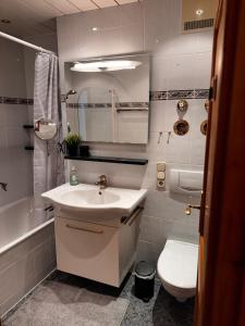 a white bathroom with a sink and a toilet at Kerstin's Fewo Allgäuliebe in Fischen