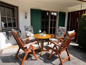 a wooden table and four chairs on a patio at Kerstin's Fewo Allgäuliebe in Fischen