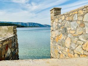 a stone wall next to a body of water at Serenity Villa in Kerveli