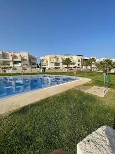 a swimming pool in front of some apartment buildings at Luxury Homes Toyo Golf Paradise Retamar in Retamar