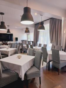 a dining room with white tables and chairs at Pensjonat Plażowy Boss z Restauracją 50 metrów od Morza in Dziwnów