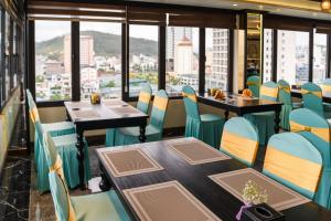 Un restaurante con mesas y sillas y vista a la ciudad. en FTE Ha Long Hotel, en Ha Long