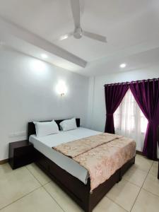 a bedroom with a large bed with purple curtains at Le Zaina's Fort Hotel in Cochin