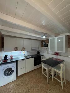 a kitchen with a washing machine and a table at Villa Luna in Corralejo