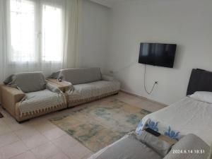 a living room with a couch and a flat screen tv at Modern Flat Walk to Shops, Cafes Harbour in Fethiye