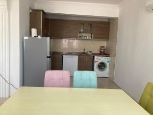 a kitchen with a table and two pink and blue chairs at Modern Flat Walk to Shops, Cafes Harbour in Fethiye +3 photos