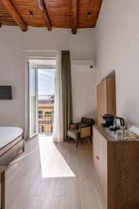 a bedroom with a bed and a desk with a chair at Riviera Collection - Rooms and Suites in Naples
