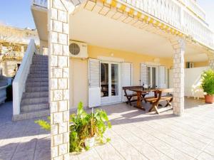 un patio de una casa con una mesa de madera en Apartments Viva, en Metajna