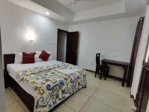 a bedroom with a bed and a desk in it at Le Zaina's Fort Hotel in Cochin +12 photos