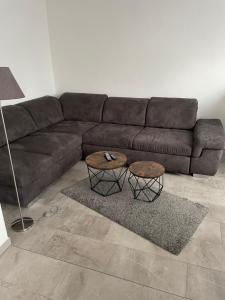 a living room with a brown couch and two tables at Schönes Appartement in der Nähe vom Schloss Herten in Gelsenkirchen