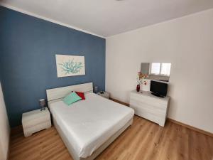 a bedroom with a white bed and a television at Maja in Chiavari
