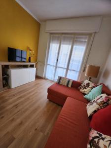 a living room with a red couch and a large window at Maja in Chiavari