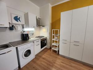 a kitchen with white cabinets and a washer at Maja in Chiavari