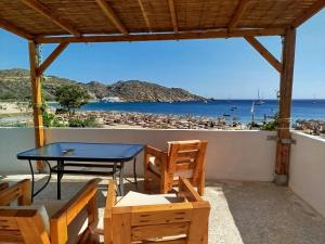 a table and chairs on a balcony with a view of the beach at Nissos Ios in Mylopotas