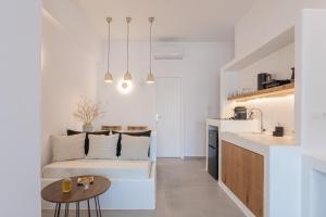 a living room and kitchen with a couch and a table at Korali in Astypalaia