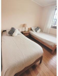 a bedroom with two beds and a window at Las Lilas in Temuco