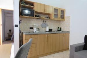 a kitchen with wooden cabinets and a microwave at Erika Medulin in Medulin