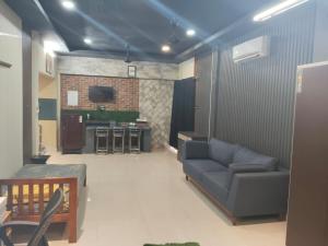 a living room with a couch and a kitchen at The PALM SUITES , Incredible India Tourism in Guwahati
