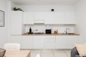 a white kitchen with white cabinets and a sink at Appartment - Joile Maisone in Porto Torres +34 photos
