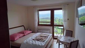 a bedroom with a bed and a large window at U Mateusza 607-737-859 in Polańczyk