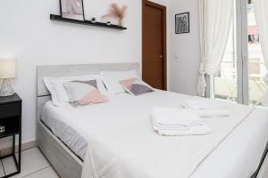 a white bed with white sheets and towels on it at Appartment - Joile Maisone in Porto Torres