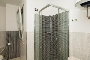 a shower with a glass door in a bathroom at Appartment - Joile Maisone in Porto Torres