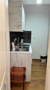 萨兰达Eri Rooms的一个小厨房，里面有水槽和炉灶。