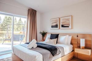a bedroom with a bed and a balcony at Huge Waterfront Modern Cottage on the Rouge River in Rivière-Rouge
