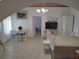 Una sala de estar con una mesa y un televisor. en A V G E R I N O S Naxos, en Naxos Chora