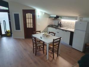 a kitchen with a table and chairs in a room at MD Apartament- Cazare la curte in Curtea de Argeş