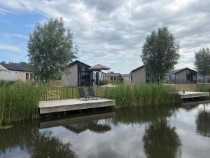 una panchina seduta su un molo accanto a un corpo idrico di De IJssel Eilanden Chalet Casa Kampen mit Zaun Nr 548 a Kampen