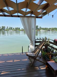 a deck with a chair and a view of the water at Splav na Savi in Ostružnica +4 photos
