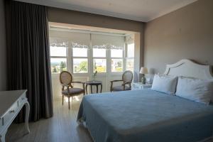 a bedroom with a bed and a table and chairs at Eritrina Alacati in Alacati