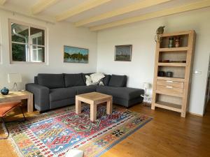 a living room with a couch and a table at Vakantiehuis Paterswoldsemeer - Potjewol in Haren +17 photos