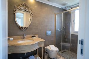 a bathroom with a sink and a toilet and a mirror at Eritrina Alacati in Alacati