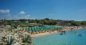a beach with umbrellas and people in the water at Casa Francesco Taranto in Taranto