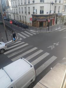 a white van parked at a crosswalk on a city street at Studio familial in Paris