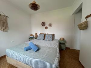 ein Schlafzimmer mit einem Bett mit blauen Kissen darauf in der Unterkunft Villa Morena in Grândola + 55 Fotos