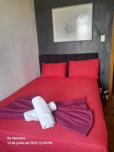 uma cama com almofadas vermelhas e duas toalhas em Centro, Maracanã privado total, SmarTV, vista panorâmica no Rio de Janeiro