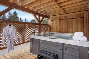 a large bathroom with a hot tub on a deck at Modern Waterfront Cottage on the Rouge River & Spa in Rivière-Rouge