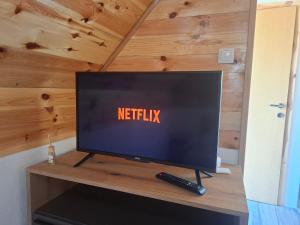 een flatscreen-tv zittend op een tafel met een afstandsbediening bij Cottage Martina in Žabljak